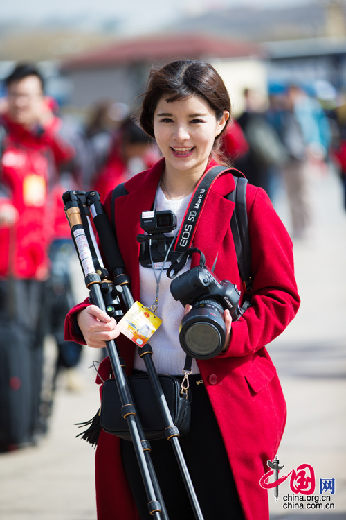2016年兩會(huì)，人民大會(huì)大堂前，一位笑容燦爛的紅衣女記者正步入大會(huì)堂。中國網(wǎng) 鄭亮 攝