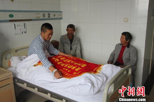 被救的李忠起、張總鳳夫婦看望受傷后的李運(yùn)飛?！⊥粲?攝
