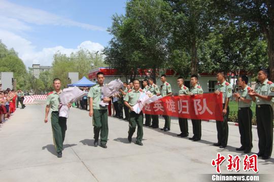部隊(duì)官兵們迎接出院歸來(lái)的李運(yùn)飛(中)和其他消防戰(zhàn)士?！⊥粲?攝
