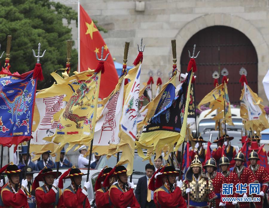 7月3日，韓國(guó)總統(tǒng)樸槿惠在青瓦臺(tái)總統(tǒng)府舉行隆重儀式，歡迎中國(guó)國(guó)家主席習(xí)近平對(duì)韓國(guó)進(jìn)行國(guó)事訪問(wèn)。這是習(xí)近平的車(chē)隊(duì)在身著民族服裝的韓國(guó)禮儀隊(duì)伍引導(dǎo)下駛?cè)肭嗤吲_(tái)。新華社記者丁林?jǐn)z  