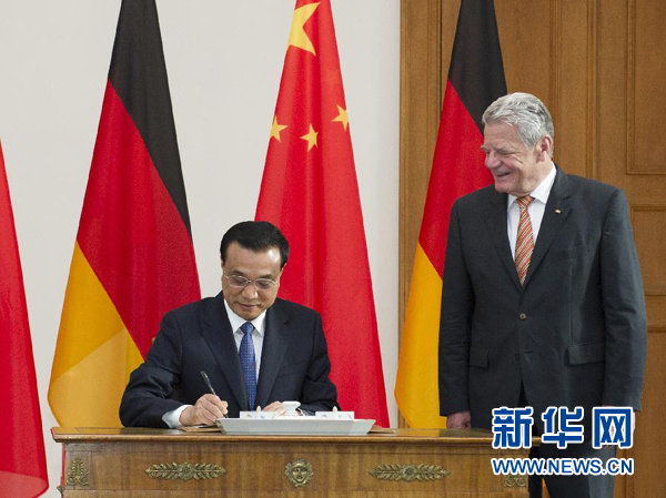10月10日，國務(wù)院總理李克強在柏林會見德國總統(tǒng)高克。這是李克強總理在高克總統(tǒng)的陪同下在貴賓簿上簽字。 新華社記者 王曄 攝 